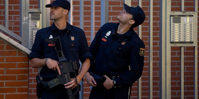 MADRID, SPAIN - JUNE 16: Two Spanish policemen guard a residence at Rutilo street during an operation against an international Jihadist recruiting network on June 16, 2014 in Madrid, Spain. Spanish Police this morning made eight arrests in raids against an Islamist cell believed to be recruiting Jihadists to fight in Syria and Iraq for ISIL (Islamic State in Iraq and the Levant)Terrorist Group. (Photo by Gonzalo Arroyo Moreno/Getty Images)