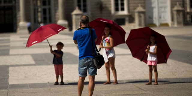 EDS NOTE : SPANISH LAW REQUIRES THAT THE FACES OF MINORS ARE MASKED IN PUBLICATIONS WITHIN SPAIN. Children pose for a photograph as they visit the Royal palace in Madrid, Spain, Friday, July 29, 2016. The number of tourists visiting Spain jumped by 12 percent in the first six months of 2016, as a mix of economic concerns and fears of extremist attacks is thought to have driven foreigners away from rival Mediterranean destinations. (AP Photo/Francisco Seco)