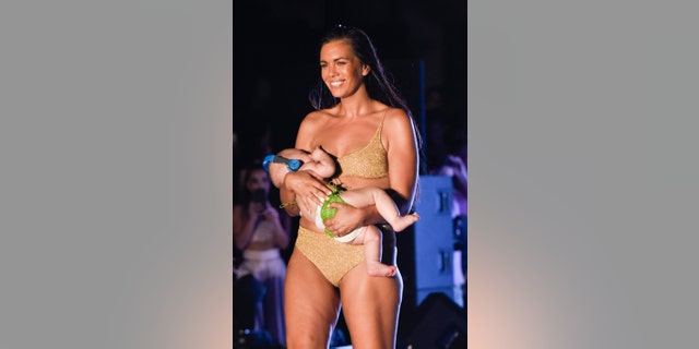 Bikini model Mara Martin breastfeeds a baby on runway at Sports Illustrated's swimsuit show in Miami.