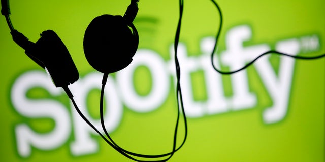 Headsets hang in front of a screen displaying a Spotify logo on it, in Zenica February 20, 2014. Online music streaming service Spotify is recruiting a U.S. financial reporting specialist, adding to speculation that the Swedish start-up is preparing for a share listing, which one banker said could value the firm at as much as $8 billion (4 billion pounds). REUTERS/Dado Ruvic (BOSNIA AND HERZEGOVINA - Tags: SCIENCE TECHNOLOGY BUSINESS SOCIETY) - RTX1975T