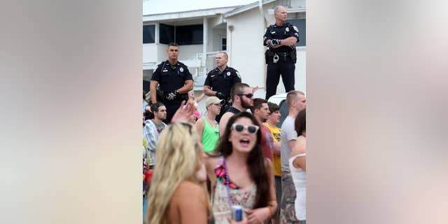 FILE - This March 11, 2014 file photo shows Panama City Beach Police Officers watching over a large crowd of spring breakers during a Luke Bryan concert in Panama City, Fla. (AP Photo/The News Herald/Panama City, Fla., Andrew Wardlow)