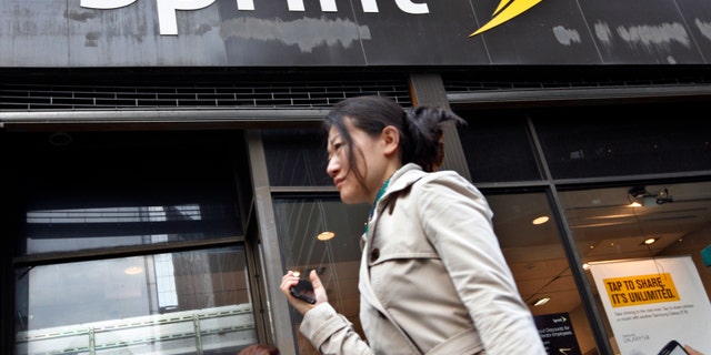 A woman walks past a Sprint store in New York's financial district, October 15, 2012.