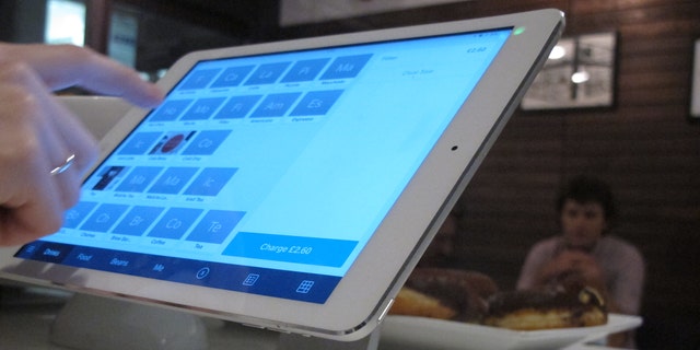 Catherine Seay demonstrates the use of Square point-of-sale software at the Curators Coffee Gallery in central London.