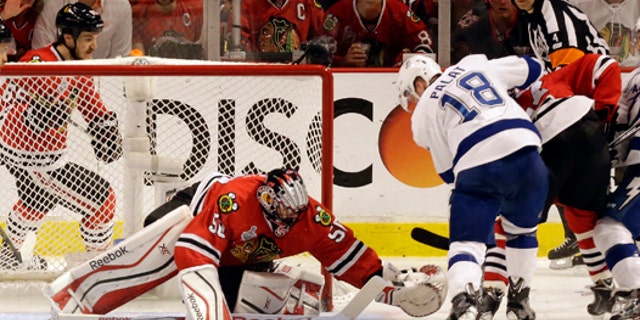June 8, 2015: The Tampa Bay Lightning's Ondrej Palat (18) scores past Chicago Blackhawks goalie Corey Crawford (50) during the third period in Game 3 of the NHL hockey Stanley Cup Final in Chicago. (AP Photo/Charles Rex Arbogast)
