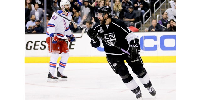 June 4, 2014: Los Angeles Kings right winger Justin Williams, right, celebrates his game winning goal as New York Rangers left wing Benoit Pouliot looks on in overtime of Game 1 in the NHL Stanley Cup Final in Los Angeles.(AP Photo/Jae C. Hong)