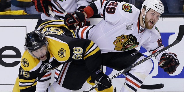 June 17, 2013: Boston Bruins right wing Jaromir Jagr (68), of the Czech Republic, ties up Chicago Blackhawks left wing Bryan Bickell (29) during the third period in Game 3 of the NHL hockey Stanley Cup Finals in Boston.