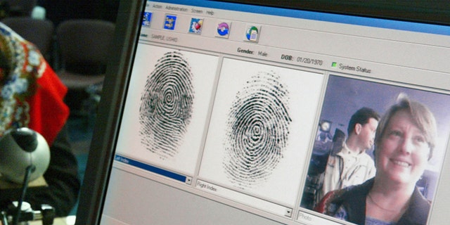 WASHINGTON - OCTOBER 28:  Penelope Smith, of the US-VISIT Program, demonstrates the process of inkless fingerprints scanning during a news conference on the program October 28, 2003 in Washington, DC. The U.S. Department of Homeland Security unveiled the US-VISIT Program, which will capture more complete arrival and departure data, such as fingerprints and mug shots, at airports and seaports from visitors who require a visa to enter the United States.  (Photo by Alex Wong/Getty Images)