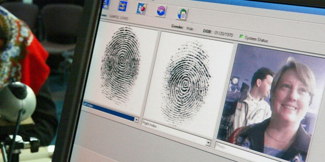 WASHINGTON - OCTOBER 28: Penelope Smith, of the US-VISIT Program, demonstrates the process of inkless fingerprints scanning during a news conference on the program October 28, 2003 in Washington, DC. The U.S. Department of Homeland Security unveiled the US-VISIT Program, which will capture more complete arrival and departure data, such as fingerprints and mug shots, at airports and seaports from visitors who require a visa to enter the United States. (Photo by Alex Wong/Getty Images)