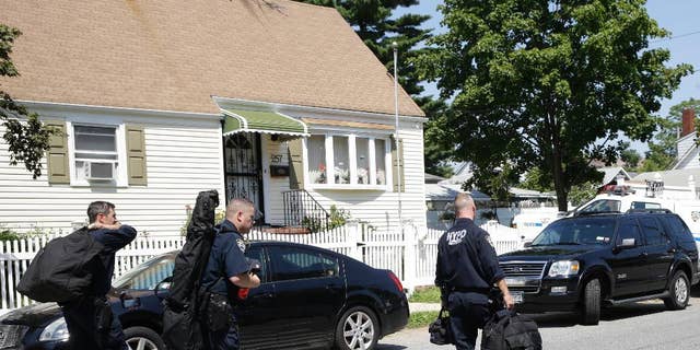 New York City Police Department Emergency Service members carry their gear as they leave the scene of a standoff, Friday, Aug. 14, 2015, in the Staten Island borough of New York. Garland Tyree, a high-ranking member of the Bloods street gang who was to be arrested on parole violations when he shot a firefighter responding to a call of smoke coming from his girlfriend's home, died Friday in a gunfight with police after a six-hour standoff, two police officials said.  (AP Photo/Mary Altaffer)