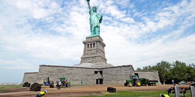 In this photo provided by the National Park Service, workers on Liberty Island install sod around the national monument in New York City, June 26, 2013. (Associated Press)