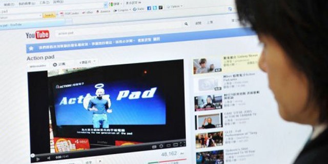 A woman looks at an Internet website in Taipei showing Taiwanese comedian A-Ken dressed up as Apple's late founder.