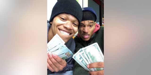 In this undated photo provided by Randy Schaefer, Dorian Walker-Gaines, left, and Dillan Thompson, pose for a selfie they unknowingly uploaded to Schaefer's iCloud account, made with Schaefer's stolen iPad holding money they allegedly took from his vehicle. Investigators arrested the pair on theft charges late Wednesday, Jan. 21, 2015, in Houston. The iPad, other electronics and thousands of dollars were stolen from the victim's truck Jan. 8. (AP Photo/Randy Schaefer)