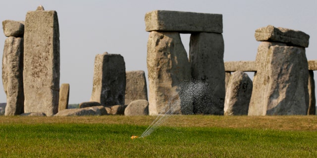 File photo - A sprinkler waters the grass surrounding the ancient site of Stonehenge, southern England April 30, 2011