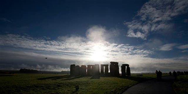 In this Tuesday Dec. 17, 2013 file photo, visitors take photographs of the world heritage site of Stonehenge, England.