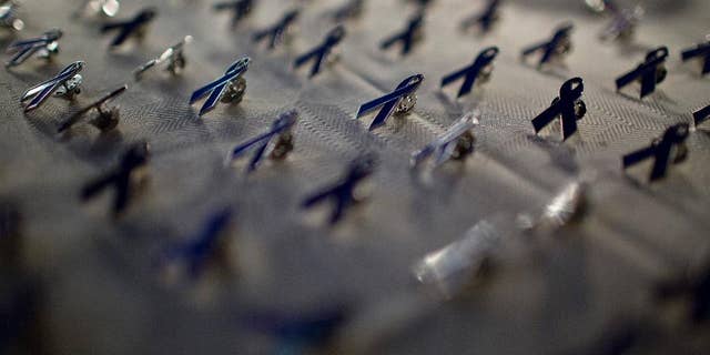 In this Oct. 1, 2014 photo, domestic violence ribbon pins are displayed for attendees of the Alabama first lady, Dianne Bentley's, domestic violence awareness candlelight vigil in Montgomery, Ala. First Lady. (AP Photo/Brynn Anderson)