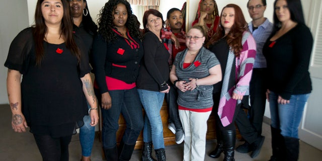 March 30, 2015: Makenzie Vasquez, from left, Pamala Hunt, Latonya Suggs, Ann Bowers, Nathan Hornes, Ashlee Schmidt, Natasha Hornes, Tasha Courtright, Michael Adorno and  Sarah Dieffenbacher, pose for a picture in Washington. Former and current college students calling themselves the Corinthian 100 say they are on a debt strike and refuse to pay back their student loans. (AP Photo/Manuel Balce Ceneta)