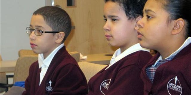 In this Feb. 25, 2014 photo, third-graders, from left, Jan Carlos Medina, Matthew Velez and Natalie Mieses take in a class that teaches them about stroke on Feb. 25, 2014, at Montefiore Hospital in the Bronx, N.Y. The hospital educates children to recognize stroke and get victims to a hospital quickly. (AP Photo/Jim Fitzgerald)
