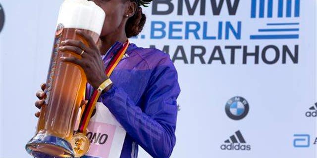 Winner Gladys Cherono tastes beer during the medal ceremony for the 42nd Berlin Marathon in Berlin on Sept. 27, 2015.