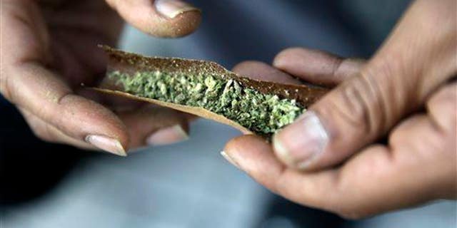 A man rolls a marijuana cigarette on Saturday, March 21, 2015, in Trenton, N.J.