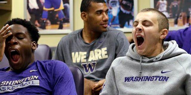 In this photo taken Sept. 28, 2015, Washington men's basketball players yawn as a classmate sits behind them during a class in Seattle.