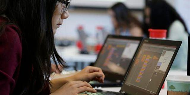 In this photo taken June 18, 2014, a teen works on completing an exercise during a "Girls Who Code" class at Adobe Systems in San Jose, Calif.