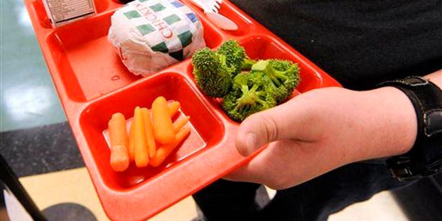 A student is shown grabbing lunch in a school cafeteria. A teacher has told the mother of a young student that the lunches she's packing for him are "very distracting for the other students and have an unpleasant odor," according to a social media post to which thousands replied. 