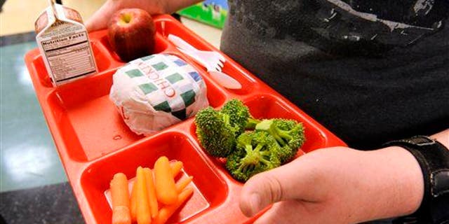 A student is shown grabbing lunch in a school cafeteria. A teacher has told the mother of a young student that the lunches she's packing for him are "very distracting for the other students and have an unpleasant odor," according to a social media post to which thousands replied. 