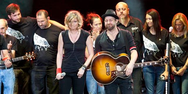 August 18: Surrounded by their tour crew, Sugarland duo Jennifer Nettles and Kristian Bush react after performing in Albuquerque, N.M. during a tribute for the victims of a stage collapse at the Indiana State Fair that killed six people.