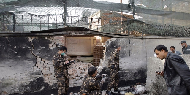 Nov. 21, 2012: Afghan security men inspect the scene of a suicide attack in Kabul, Afghanistan.