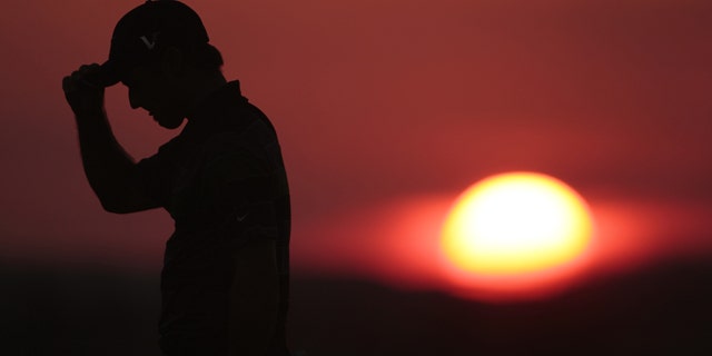 Trevor Immelman of South Africa walks off the 10th hole as the sun sets during the first round of the PGA Championship golf tournament Thursday, Aug. 12, 2010, at Whistling Straits in Haven, Wis. (AP Photo/Charlie Riedel)