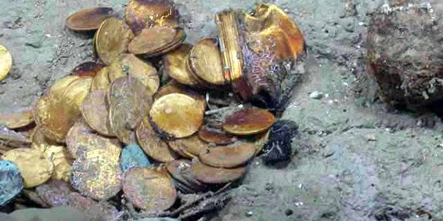 Gold coins and a gold box lie in situ on the "Black Swan" site. Hundreds of gold coins and more than 500,000 silver coins were discovered on the site.