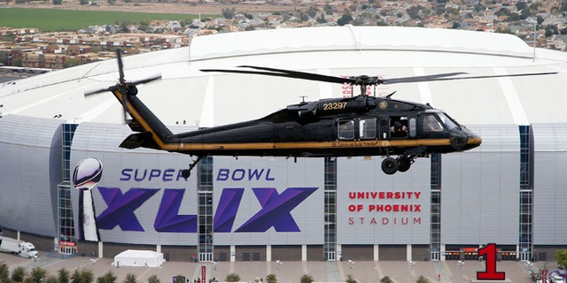 A U.S. Customs and Border Protection Black Hawk helicopter flies above University of Phoenix Stadium, site of Super Bowl XLIX football game, during a security demonstration for the media Monday, Jan. 26, 2015, in Glendale, Ariz. The helicopters and truck-sized X-ray machines that are typically deployed along the U.S.-Mexico border have been brought to the Super Bowl venue to assist with the security effort. (AP Photo/Ross D. Franklin)