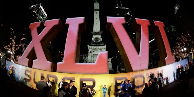 Feb. 1, 2012: In this photo taken with a fisheye lens, football fans pose for photos in front of the Super Bowl XLVI logo on Monument Circle in Indianapolis. The New England Patriots are scheduled to face the New York Giants in Super Bowl XLVI on Feb. 5.