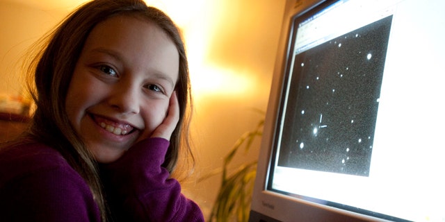 Ten-year-old Kathryn Gray sits next to a computer at the family's home in Birdton, New Brunswick, Canada, a suburb of Fredericton, on Monday, Jan. 3, 2011. On the computer monitor is an image in which she discovered a supernova. The Royal Astronomical Society of Canada says she made the discovery on the weekend under the watch of two other astronomers.