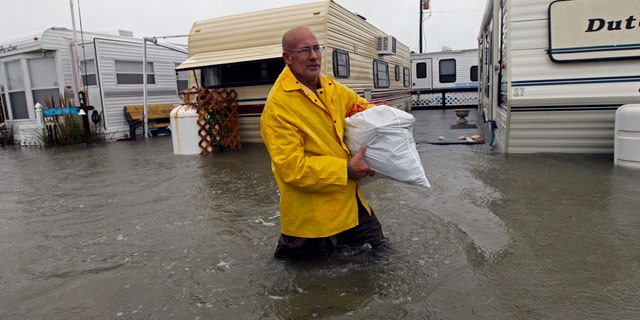Oct. 29, 2012: Terry Robinson wades through water after retrieving some of his belongings from his flooded trailer at RV Park in Kitty Hawk, N.C., Monday.