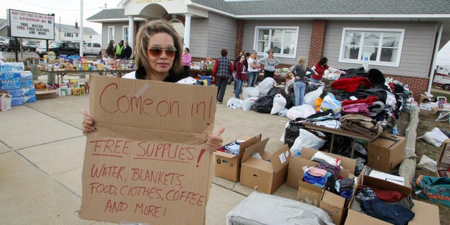 Nov. 10, 2012: Victoria Tribue, 21, volunteer member from Quakertown Pa., holds a sign advertising free supplies at the Surf City Volunteer Fire & EMS Station on Long Beach Island, N.J., after Superstorm Sandy.
