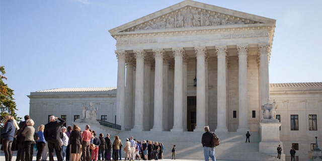 In this Monday, Oct. 6, 2014 photo, people wait to enter the Supreme Court in Washington as it begins its new term.