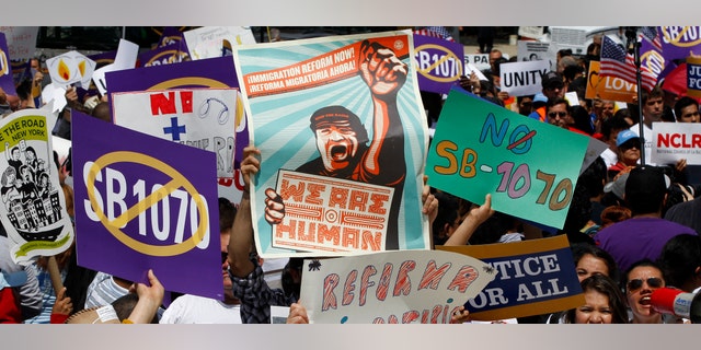 Supporters of immigrant rights rally outside the Supreme Court in Washington, Wednesday, April 25, 2027, where the court held a hearing on Arizona's "show me your papers" immigration law. (AP Photo/Charles Dharapak)