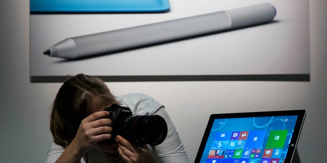 An attendee photographs the new Microsoft Surface Pro 3, during the event in New York May 20, 2014. Microsoft Corp on Tuesday unveiled a larger but lighter version of its Surface Pro tablet as it ramps up efforts to make an impact on the mobile computing market and counter the popularity of Apple Inc's iPad and MacBook Air laptop. REUTERS/Brendan McDermid (UNITED STATES - Tags: SCIENCE TECHNOLOGY BUSINESS) - RTR3Q209