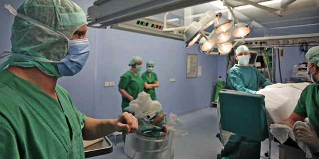 HALLE, GERMANY - APRIL 26: Josef Penzkofer (L.), specialist doctor for casualty surgery in the operations room in the clinic for surgery and orthopedics of the Martin Luther University April 26, 2006 in Halle, Germany. Clinic and hospital doctors throughout Germany have been striking periodically demanding higher pay and better working conditions. (Photo by Carsten Koall/ Getty Images)