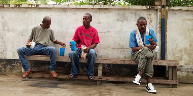 FILE - In this Jan. 27, 2014 file photo, homeless men eat breakfast at a shelter for the homeless in Paramaribo, Suriname. Life has become exceedingly hard in Suriname in 2016, where the economy has been in free-fall amid the collapse of global commodity prices and the slide of the local currency relative to the U.S. dollar. (AP Photo/Ertugrul Kilic, File)