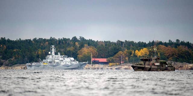 The Swedish minesweeper HMS Kullen, left, and a guard boat in Namdo Bay, Sweden,Tuesday, Oct. 21, 2014 on their fifth day of searching for a suspected foreign vessel in the Stockholm archipelago. The navy has demanded a 1000-meter (yard) no-go radius around naval vessels taking part in the current operation. (AP Photo/TT News Agency, Fredrik Sandberg) SWEDEN OUT