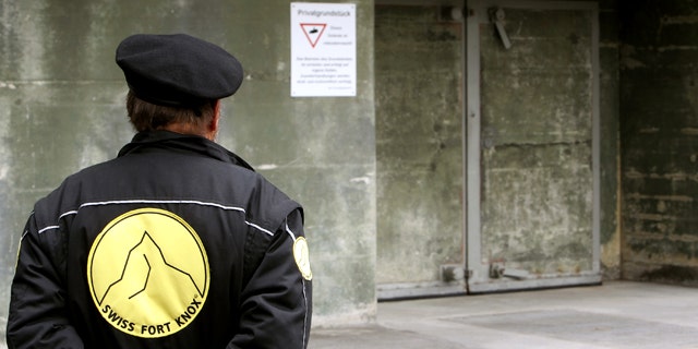 A security guard stands in front of a gate of the Swiss Fort Knox bunker in the mountains near the Swiss Alpine resort of Saanen May 18, 2010. In the secret bunker, European researchers deposited a "digital genome" that will provide the blueprint for future generations to read data stored using defunct technology.