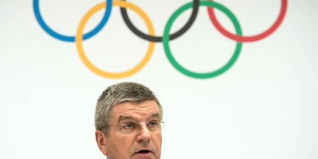 FILE - This is a Monday, July 7, 2014 file photo of International Olympic Committee, IOC, President Thomas Bach of Germany, as speaks during the announcement of the 2022 Olympic Winter Games Candidate Cities (Beijing 2022, Oslo 2022, Almaty 2022) after an executive board meeting, at the IOC headquarters in Lausanne, Switzerland. The IOC will not reopen the bidding process for the 2022 Winter Games after Oslo's withdrawal left just two cities in the race, IOC President Thomas Bach told The Associated Press on Thursday Oct. 2, 2014. (AP Photo/Keystone,Jean-Christophe Bott, File)