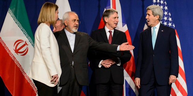 FILE - In this file photo taken Thursday, April 2, 2015, from left, EU High Representative for Foreign Affairs and Security Policy, Federica Mogherini, Iranian Foreign Minister, Mohammad Javad Zarif, British Foreign Secretary, Philip Hammond, and U.S. Secretary of State, John Kerry, line up for a press announcement after a new round of Nuclear Iran Talks in the Learning Center at the Swiss federal Institute of Technology (EPFL) in Lausanne, Switzerland.