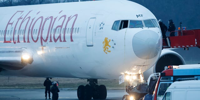 Police stand around the aircraft after passengers were evacuated from a hijacked Ethiopian Airlines Plane on the airport in Geneva, Switzerland, Monday, Feb. 17, 2014. A hijacked aircraft traveling from Addis Abeda, Ethiopia, to Rome, Italy, has landed at Geneva's international airport early Monday morning. Swiss authorities have arrested the hijacker. (AP Photo/Keystone, Salvatore Di Nolfi)