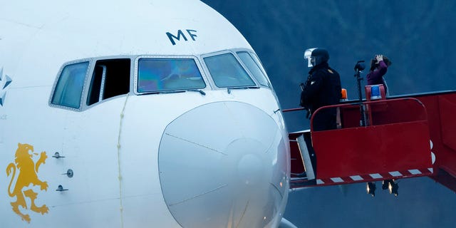 Police stand on the stairs after passengers were evacuated from a hijacked Ethiopian Airlines Plane on the airport in Geneva, Switzerland, Monday, Feb. 17, 2014.The aircraft traveling from Addis Abeda, Ethiopia, to Rome, Italy, has landed at Geneva's international airport early Monday morning. Swiss authorities have arrested the co-pilot. (AP)