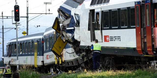 July 29, 2013 - Police inspect the site where two passenger trains collided head-on in Granges-pres-Marnand, western Switzerland. Dozens of people have been injured.