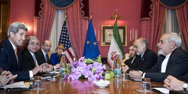 U.S. Secretary of State John Kerry, left, U.S. Secretary of Energy Ernest Moniz, second left, National Security Council point person on the Middle East Robert Malley, 3rd left, and European Union Political Director Helga Schmid. 4th left, head of the Iranian Atomic Energy Organisation Ali Akbar Salehi 2nd right, and Iranian Foreign Minister Mohammad Javad Zarif right wait for the start of a meeting at a hotel in Lausanne Switzerland on Thursday March 26, 2015 during negotiations on the Iranian nuclear programme. (AP Photo/Brendan Smialowski, Pool)