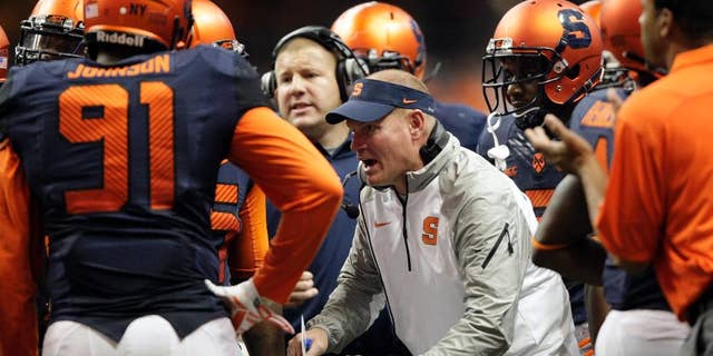 FILE - In this Oct. 3, 2014, file photo, Syracuse’s head coach Scott Shafer talks to his players during a timeout in the third quarter of an NCAA college football game against Louisville in Syracuse, N.Y. Shafer has shuffled his staff as the Orange prepare to host top-ranked Florida State. (AP Photo/Nick Lisi, File)